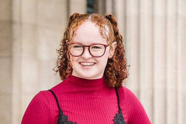 Ellena smiling at the camera with the entrance to the Parkinson Building in the background.