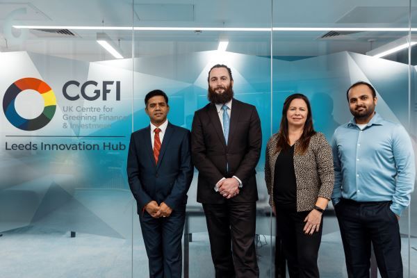 A group of four people stood by the CGFI logo