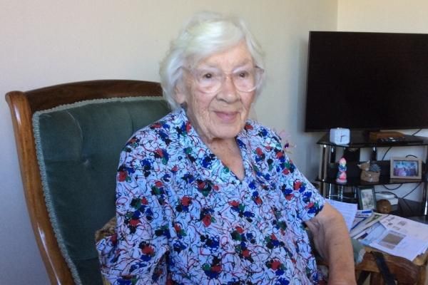 Brenda smiles at the camera, sitting at a desk chair.