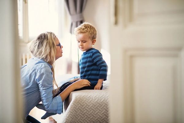 A middle aged women comforts a small child who looks on the verge of tears.