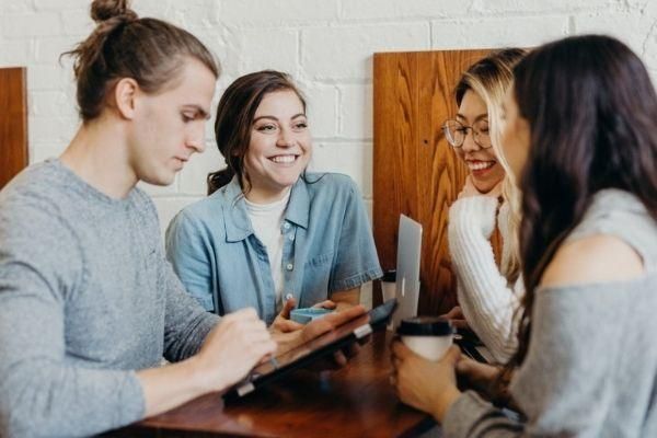 Four students having a chat in a cafe.