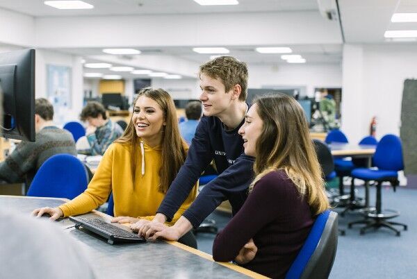 Three students using a computer