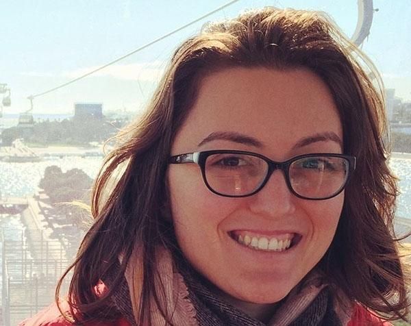 Leeds alumna Maria Ventura smiling with a blue sky and cable cars in the background