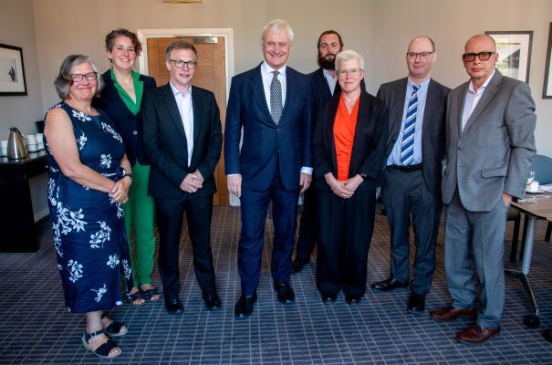 The Minister for Energy Security and Net Zero is stood with a group of seven people who are members of the Climate Change Committee and took part in the board meeting. 