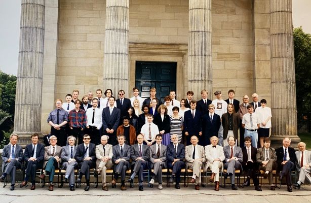 Lecturers and students sit for formal photograph in front of the building on St George's Field