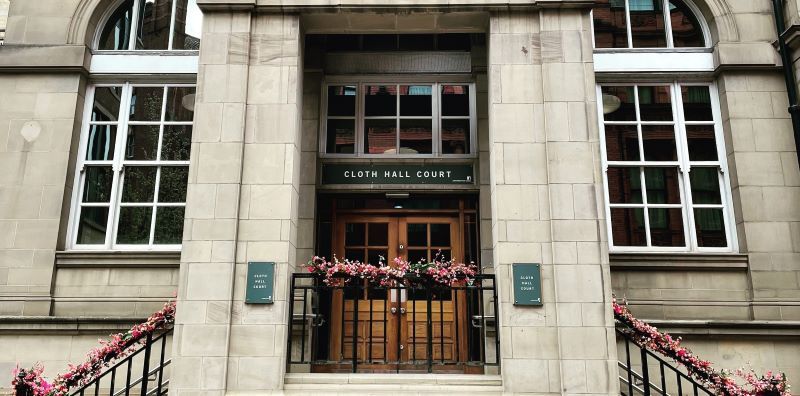 The entrance to Cloth Hall Court in Leeds. Two staircases lead up to the door.