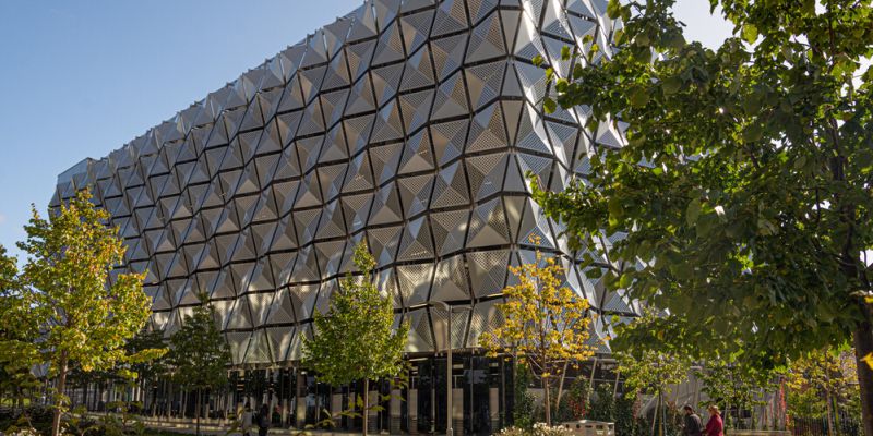 The architectural silver multi-story carpark on campus, surrounded by trees.