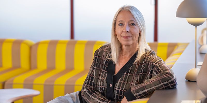 Profile image of Jane Featherstone sat on a sofa