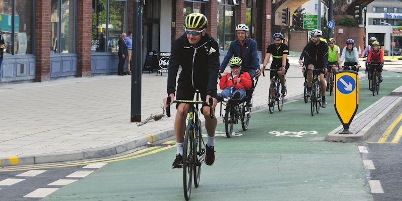 Alistair Brownlee cycling on a cycle lane in Leeds city centre