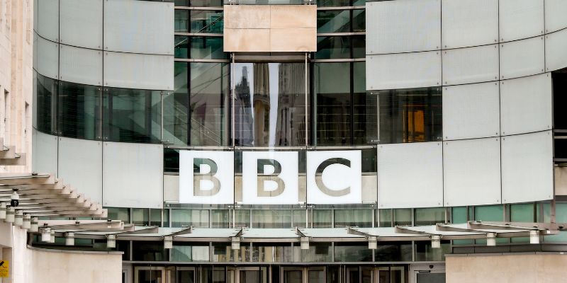 The BBC logo on Broadcasting House, a large, curved, glass-fronted building