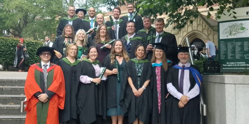 University of Leeds Chartered Manager degree apprenticeship students in their graduation gowns, alongside programme leaders