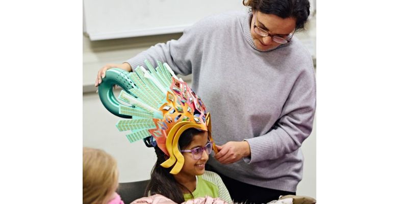A Brownie tries on carnival headgear with Professor Briony Thomas