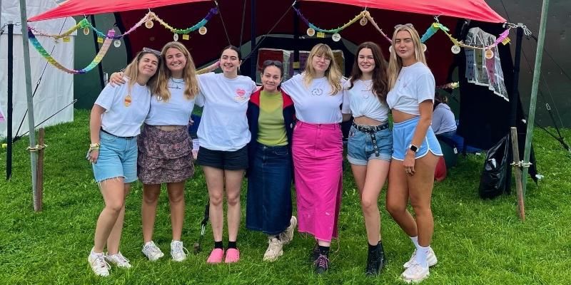 A line-up of festival goers including Della on the far left and Elysia on the far right in front of a tent at Leeds Festival
