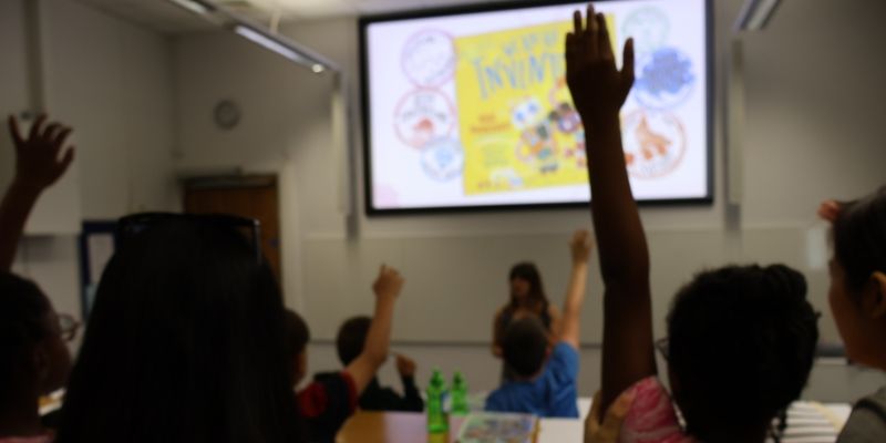 Pupils raise their hands in a lecture