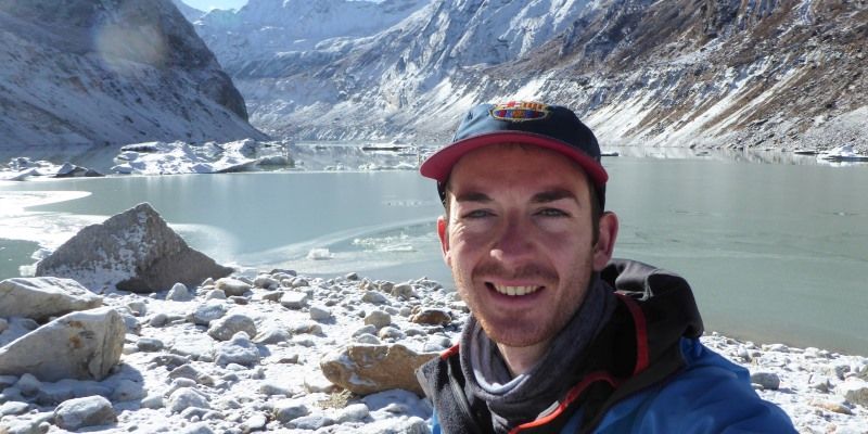 Dr Watson pictured in front of a glacier and lake.