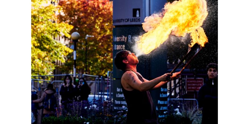 Man breathing fire in front of crowd