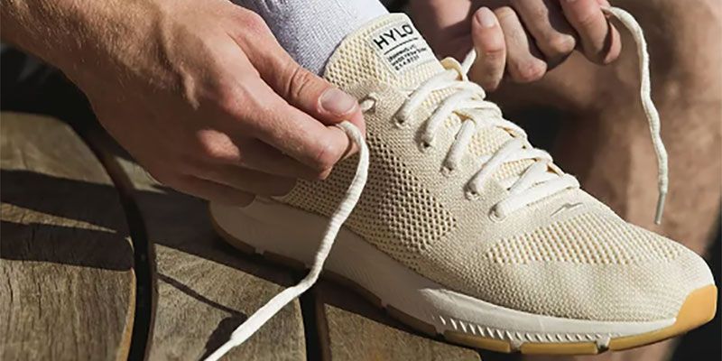 A cream-coloured trainer being laced up.