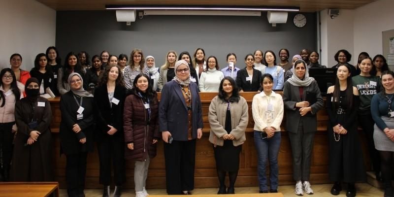 A group of people in a lecture theatre smiling at the camera at the IEEE summit.
