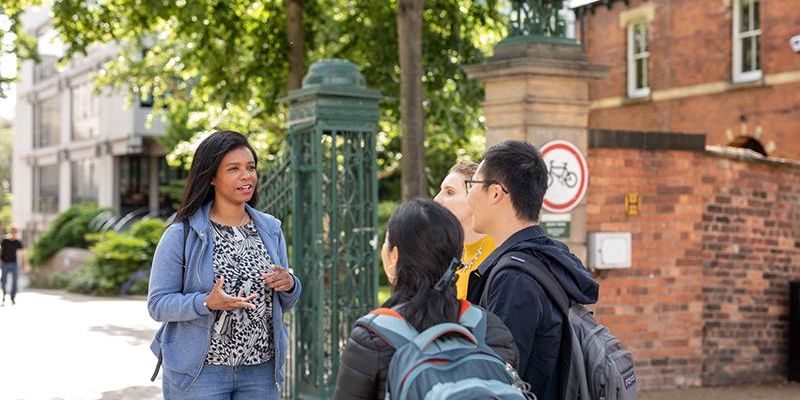 3名学生在利兹大学校园巡演中听导游讲解。