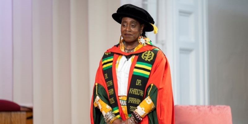 Khadijah Ibrahiim stands in red and green gowns