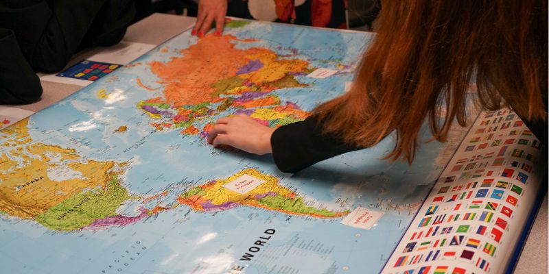 School pupils point at a map