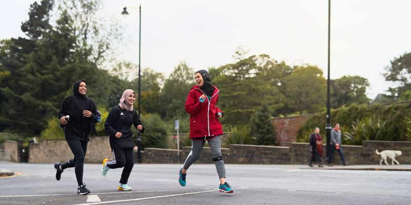 Namrah Shahid running with two members of her running club in Roundhay Park in Leeds.