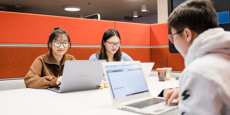 Three students working in the University library.
