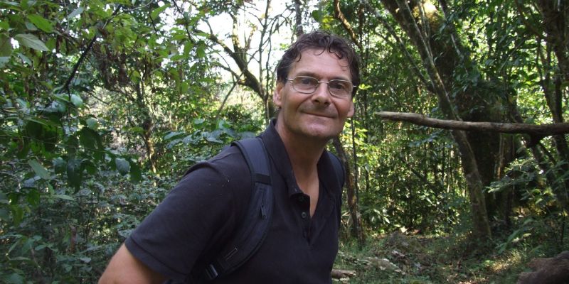 Professor Jon Lovett in the Tanzanian forests, wearing a navy polo shirt and looking at the camera.