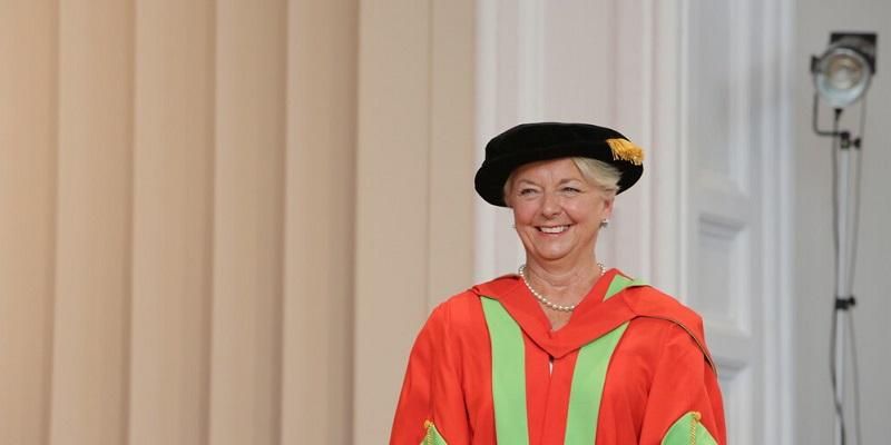 The image shows Dr Linda Pollard in her academic gowns after receiving her honorary doctrate in laws at the University of Leeds. She is smiling.