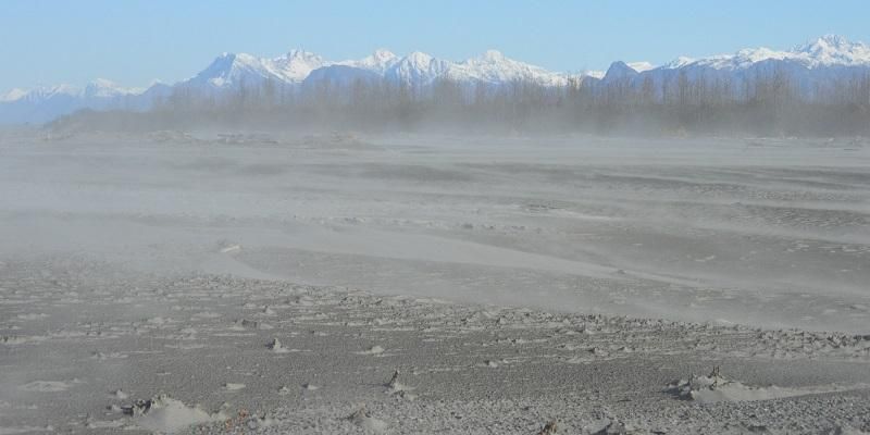 Image shows a fine, grey-coloured dust blowing across the valley and reducing visibility. This is glacial dust which is lofted up into the air from the river bed at times of low water levels and is carried hundreds of miles over north America and into the atmosphere.