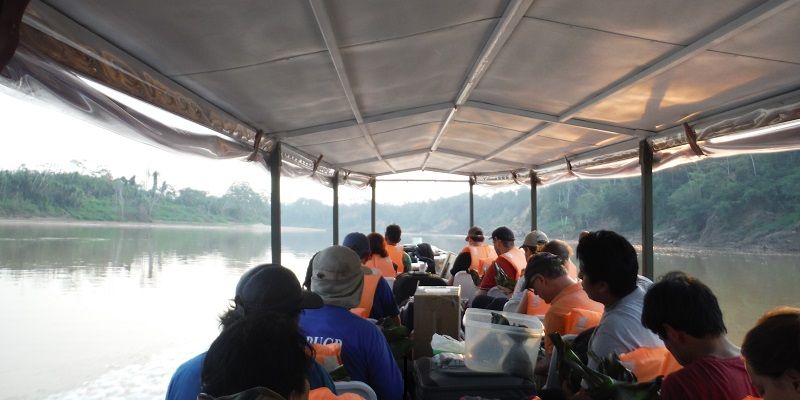 Scientists travelling by boat into the rainforest