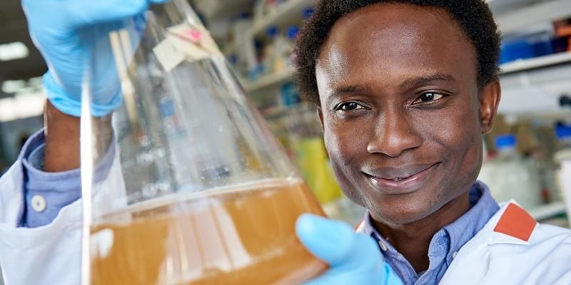 Picture shows a scientist with a batch of virus like particles engineered in years