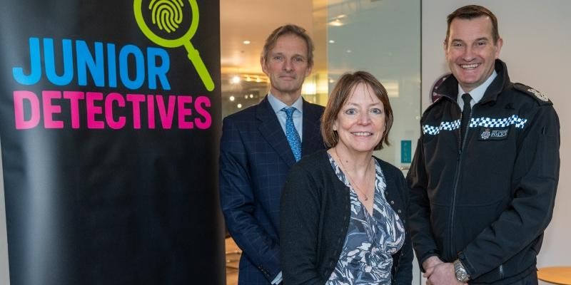 Standing next to a Junior Detectives banner are from left His Honour Judge Kearl, Vice-Chancellor of the University of Leeds Shearer West and Chief Constable of West Yorkshire John Robins.