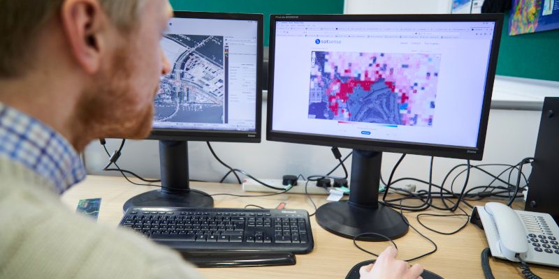 SpaceSense employee viewing satellite data on two computer screens.