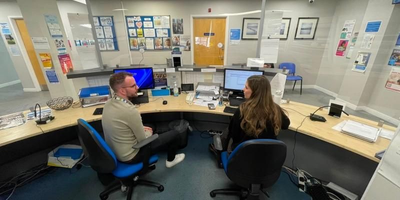 The Business Manager and the Patient Navigator at The Light Surgery in Leeds sit on reception and chat to each other.