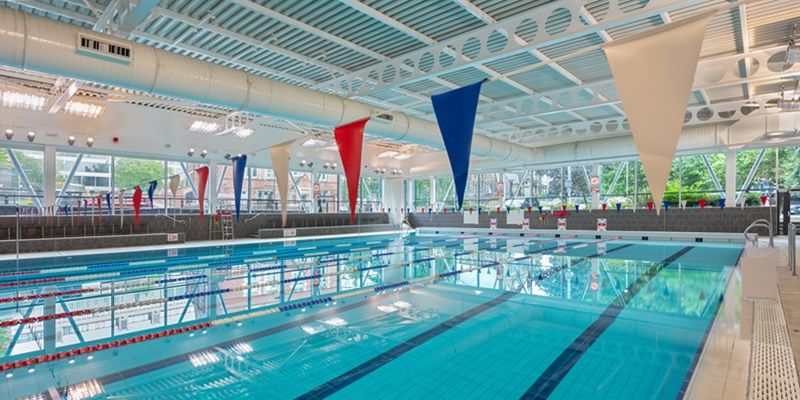 A large brightly lit swimming pool with bunting hanging above it.