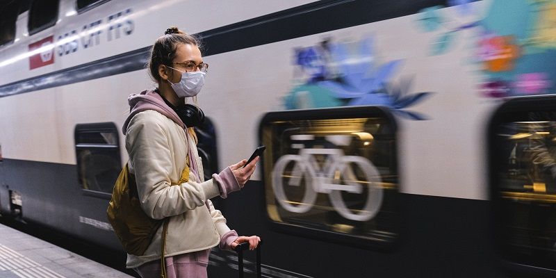 Woman outside train with facemask on
