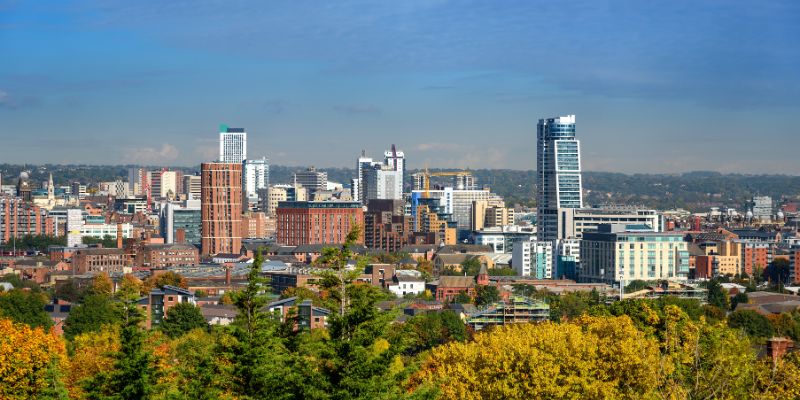 Leeds city skyline with a variety of trees in the foreground