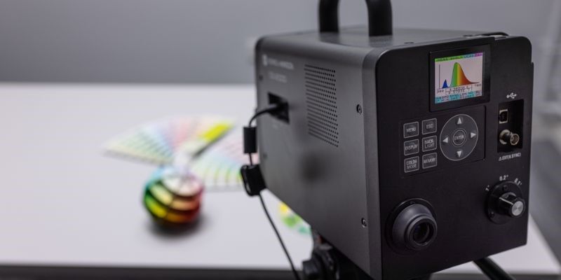 A lighting camera assessing colour charts on a table.