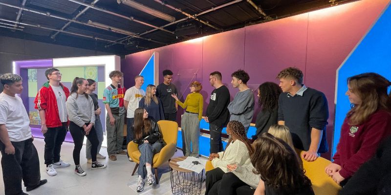Journalism students receive feedback from Channel 4's team in the purple Channel 4 news set