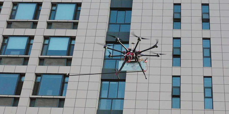 The drone-mounted WideSee system hovers alongside a high-rise building.