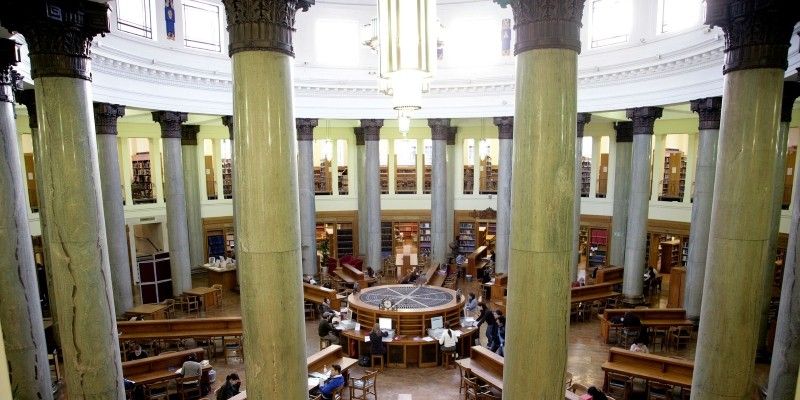 The library in the parkinson building, with studetns working at desks surrounded by books.