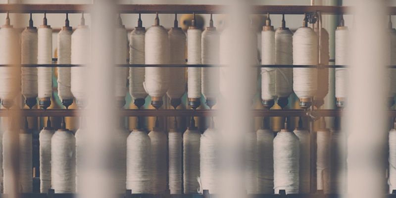 White textile spools lined up in a row.