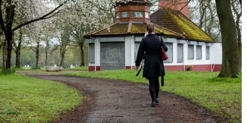 a woman walks across Woodhouse Moor alone