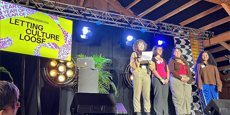 Four persons on a stage next to a screen which says: letting culture loose.