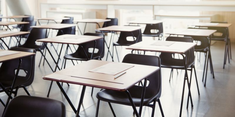 Rows of empty school desks and chairs