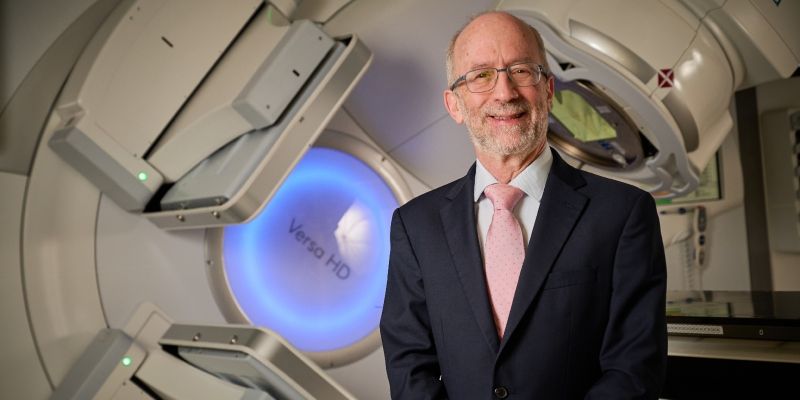 Professor David Sebag-Montefiore in front of a radiotherapy machine