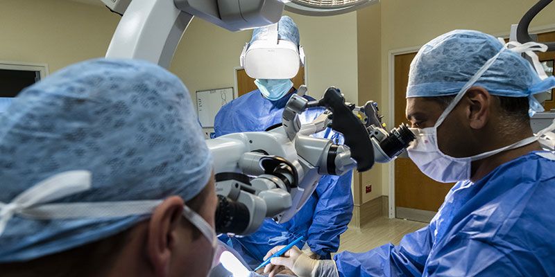 Surgeons wearing scrubs and using immersive technology
