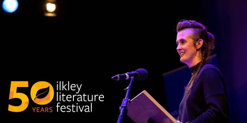 Professor Kimberly Campanello performs at a poetry reading. Ilkley Literature Festival: 50th anniversary logo appears on the left.