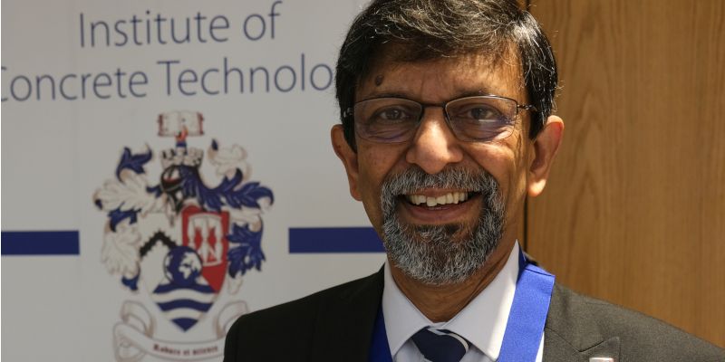 Professor Basheer head and shoulders, wearing a suit, looking at the camera and smiling
